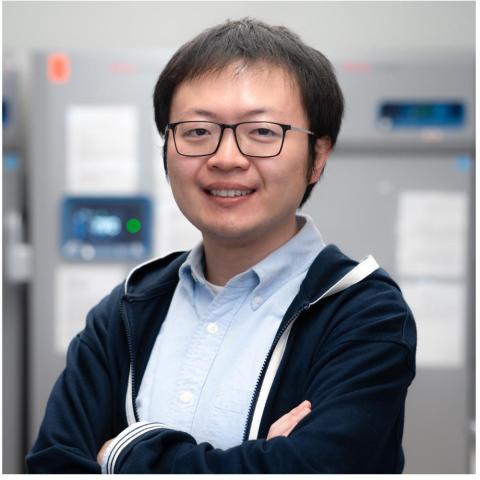Headshot of Haonan Lin. An Asian man with glasses wearing a light blue button-up shirt under a navy jacket.